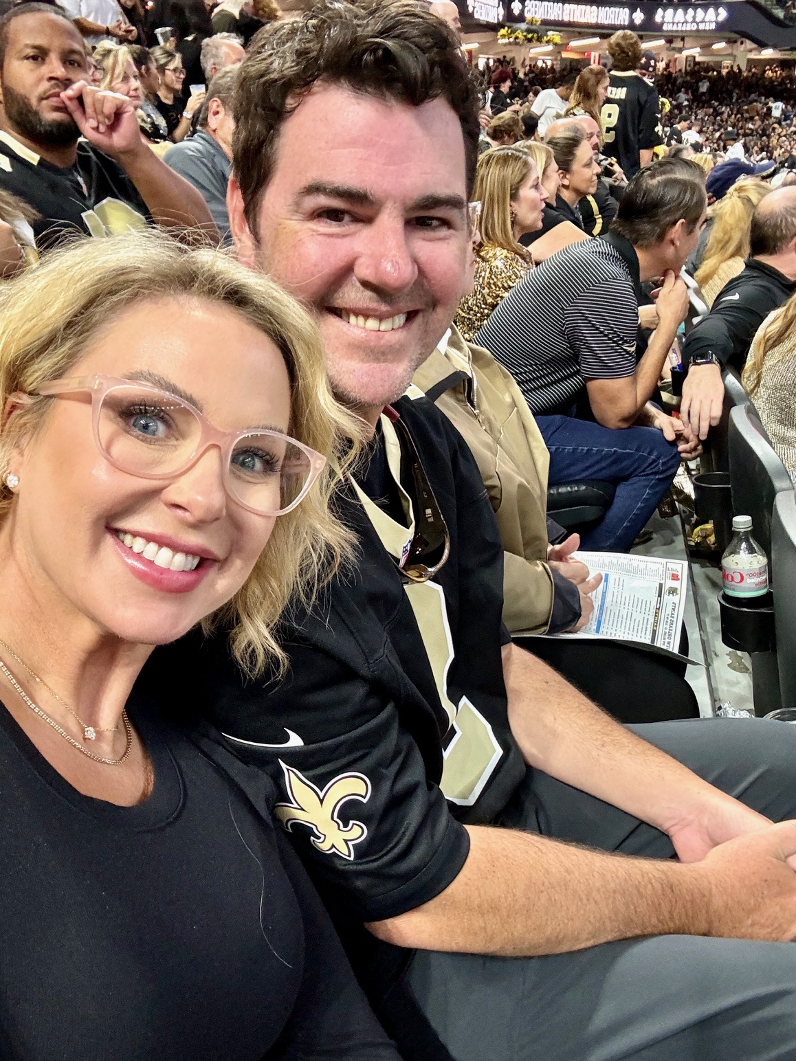 Meredith and Jason smiling in stands at Saint's game